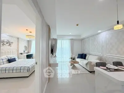 Modern open-plan living room and bedroom with elegant decor and natural light.