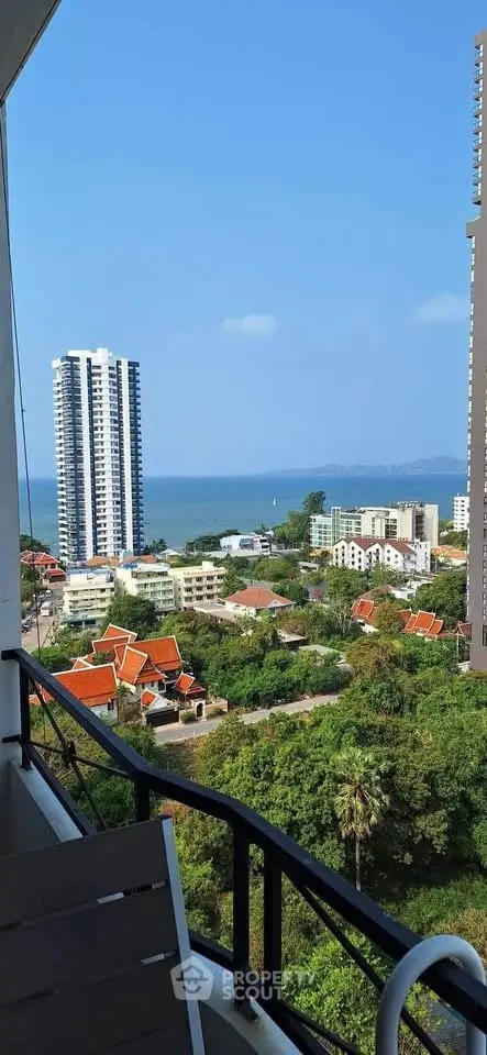 Stunning ocean view from high-rise balcony overlooking cityscape and greenery.
