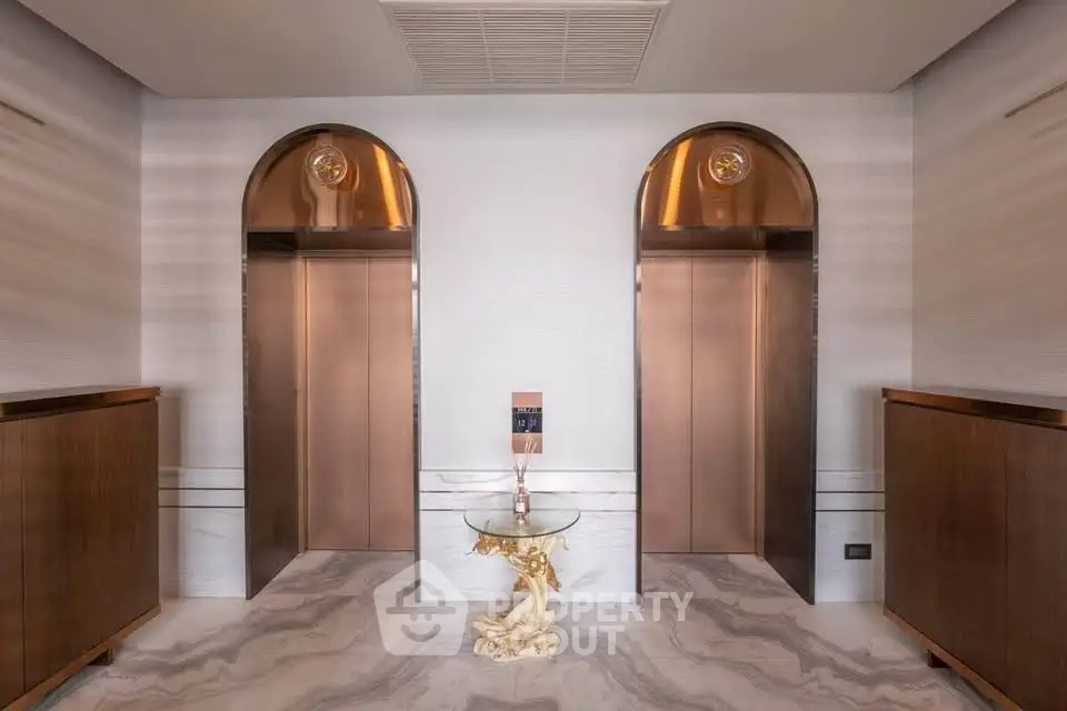 Luxurious building lobby with elegant dual elevators and stylish decor