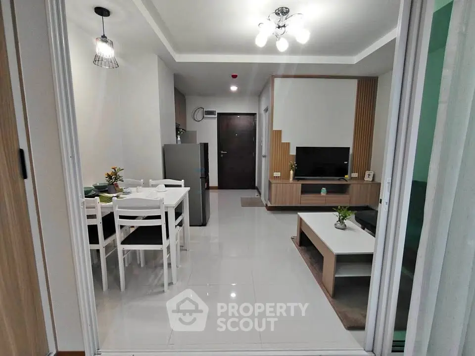 Modern open-plan living room and dining area with sleek furniture and bright lighting.