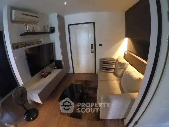 Cozy living room with modern decor and wall-mounted TV in a stylish apartment.