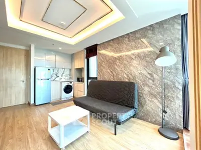 Modern living room with stylish lighting, sleek furniture, and integrated kitchen appliances.