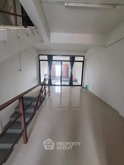 Spacious interior with modern staircase and large windows, perfect for customization.
