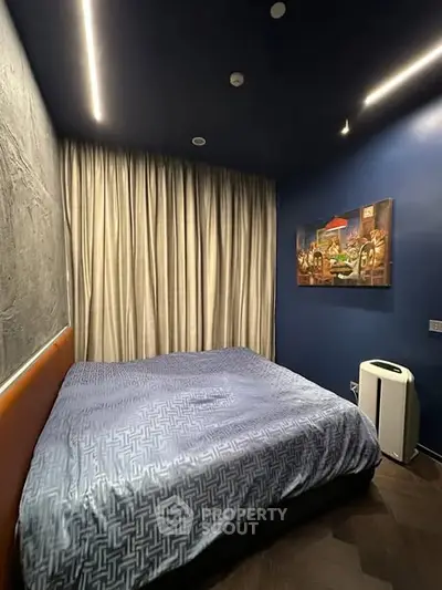 Cozy modern bedroom with blue walls and stylish lighting