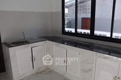 Modern kitchen with sleek countertops and large window for natural light.