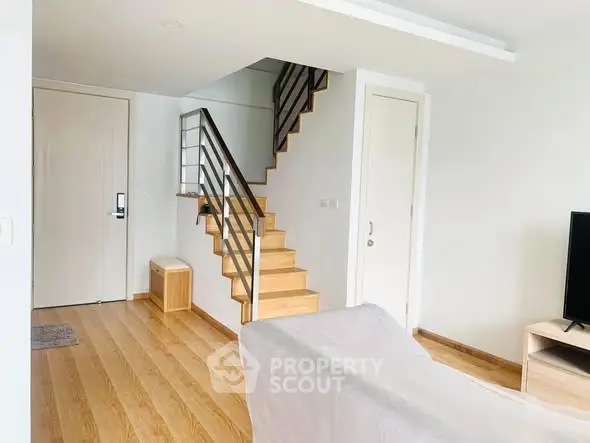 Modern living room with wooden staircase and sleek interior design