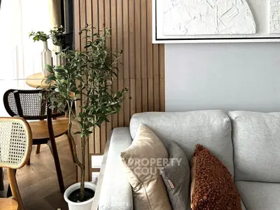 Stylish living room with modern decor, featuring a cozy sofa and elegant dining area.