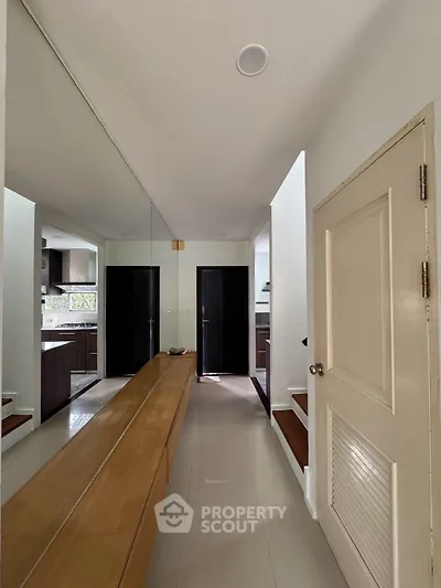 Modern kitchen with sleek cabinetry and open layout, featuring a long wooden counter and stylish design.