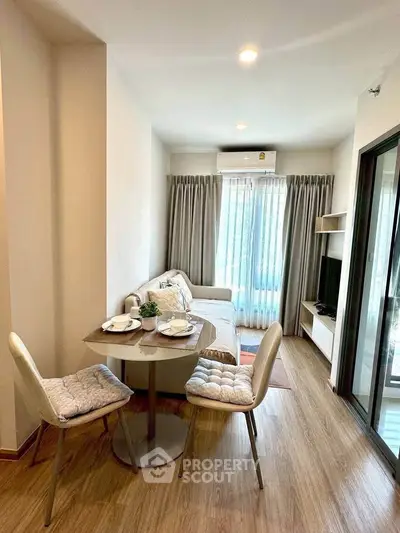 Cozy living room with dining area, modern decor, and natural light in a stylish apartment.
