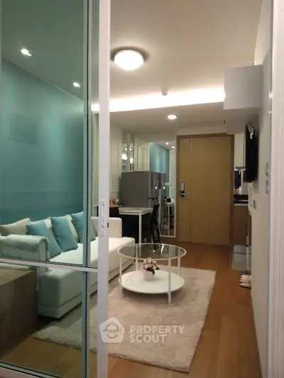 Modern living room with glass door, cozy sofa, and stylish decor in a contemporary apartment.