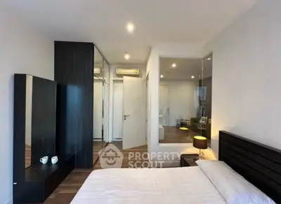 Modern bedroom with sleek design, featuring a glass partition and stylish furnishings.