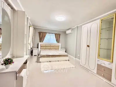 Spacious modern bedroom with elegant furnishings and natural light.