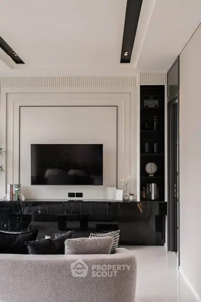 Luxurious modern living room with sleek black marble accents and wall-mounted TV.