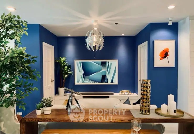 Stylish living room with modern decor, blue accent wall, and elegant lighting.