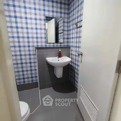 Compact bathroom with modern sink and plaid wall design