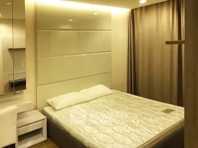 Modern bedroom with cozy lighting and elegant decor in a stylish apartment.