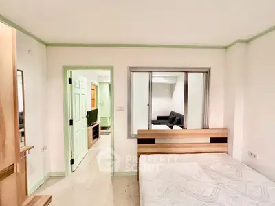 Modern bedroom with adjacent living room, featuring sleek design and neutral tones.