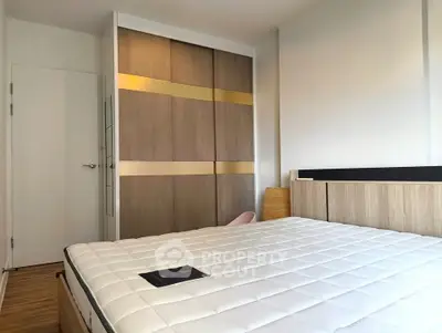 Modern bedroom with stylish wooden wardrobe and comfortable mattress in a bright apartment.