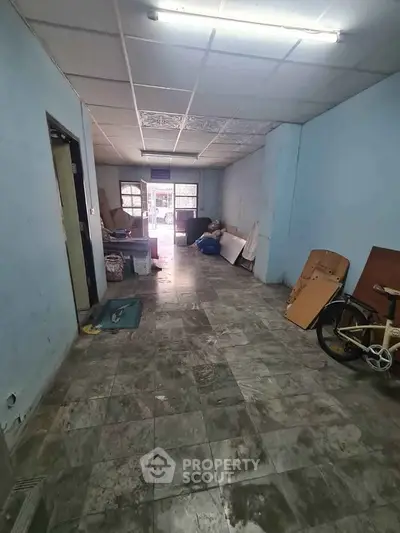 Spacious interior with potential for renovation, featuring tiled flooring and ample natural light.
