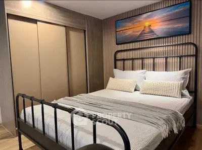 Cozy bedroom with modern decor and stylish artwork, featuring a comfortable bed and elegant lighting.