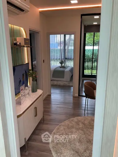 Modern apartment interior with stylish decor, featuring a cozy living area and a glimpse into a chic bedroom.