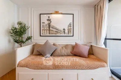 Charming living room corner with cozy seating and elegant wall art, perfect for relaxation.