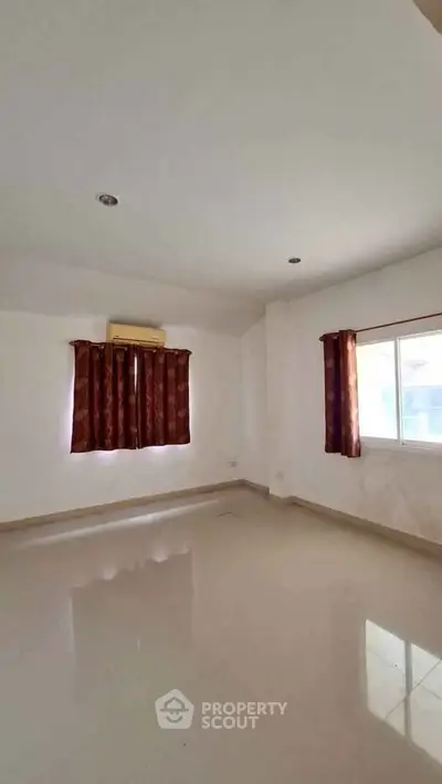 Spacious empty room with large windows and air conditioning, perfect for customization.