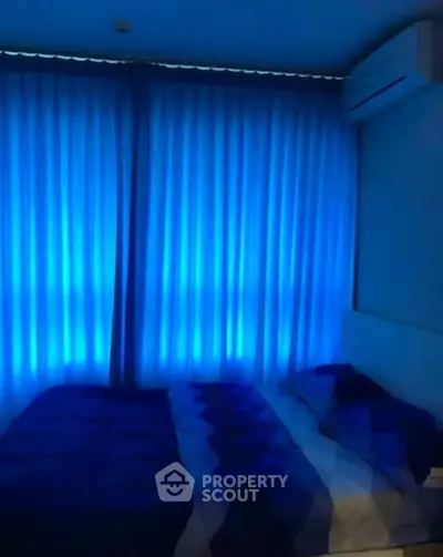 Cozy bedroom with ambient blue lighting and air conditioning, perfect for relaxation.