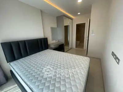 Modern bedroom with sleek design and ample natural light, featuring a comfortable bed and stylish furnishings.