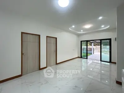 Spacious modern living room with sliding glass doors to patio