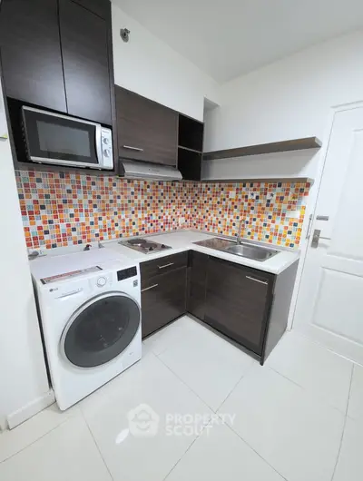 Modern compact kitchen with colorful backsplash and appliances