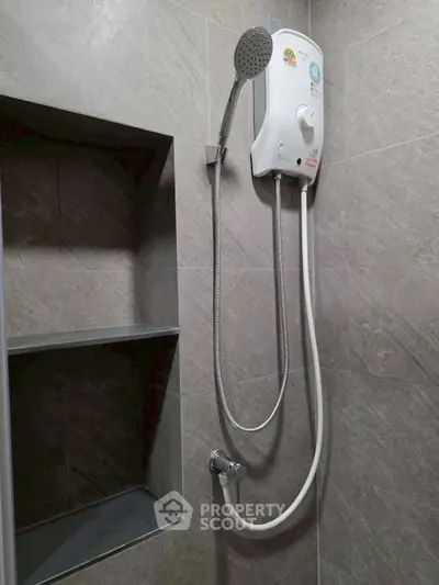 Modern bathroom with sleek shower unit and built-in shelving, perfect for contemporary living.