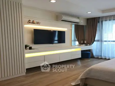 Modern bedroom with sleek TV unit and ambient lighting