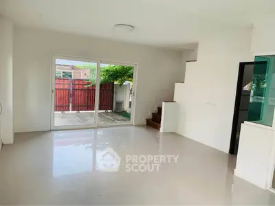 Spacious living room with sliding doors to patio and wooden staircase