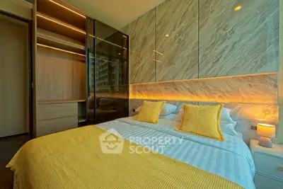 Luxurious bedroom with modern design and ambient lighting, featuring stylish yellow accents and sleek wardrobe.