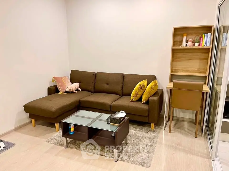 Cozy living room with brown sectional sofa and modern glass coffee table.