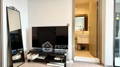 Modern living room with sleek TV setup and glimpse into stylish bathroom