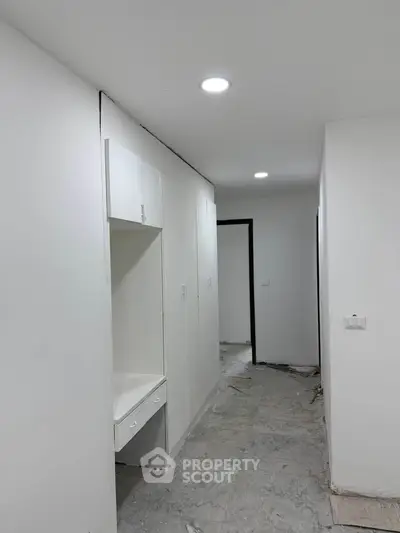 Spacious hallway with built-in storage and modern lighting in a contemporary home.