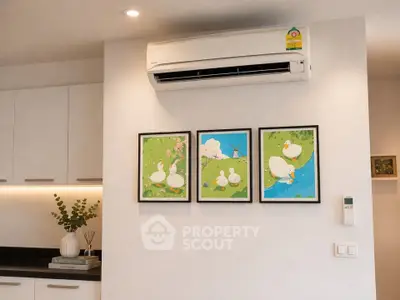 Modern kitchen interior with wall-mounted air conditioner and decorative artwork.