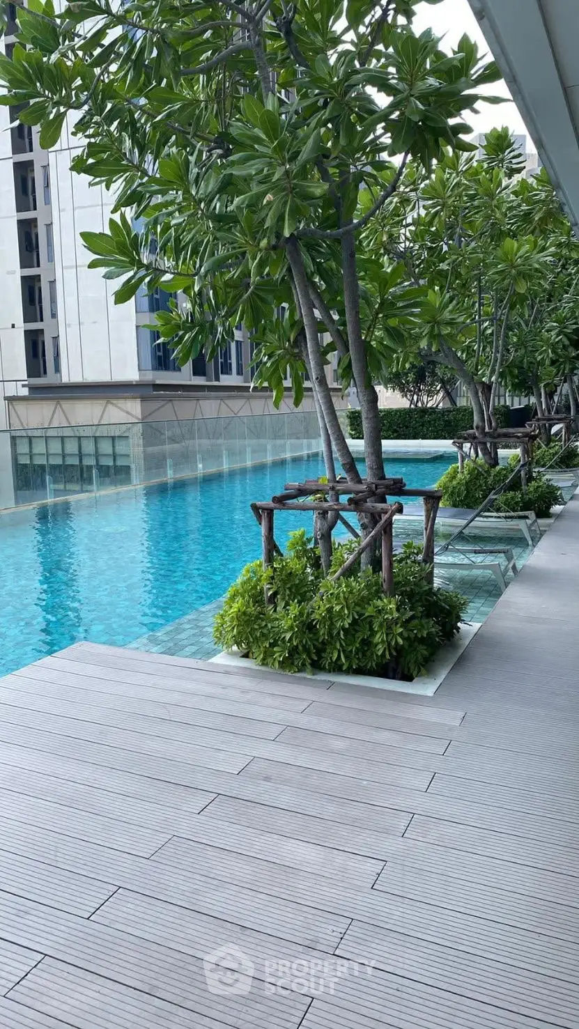 Luxurious poolside area with lush greenery and modern design, perfect for relaxation and leisure.