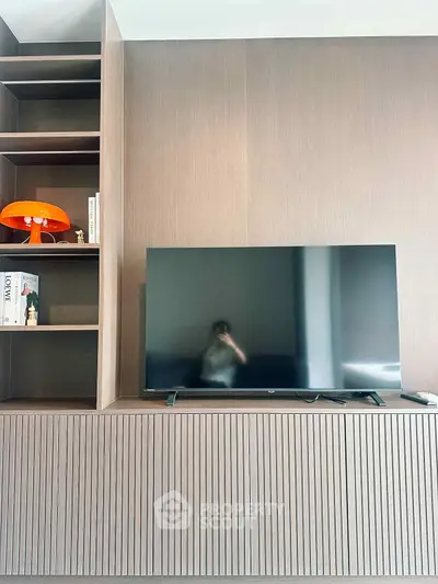 Modern living room with sleek TV setup and stylish shelving unit.