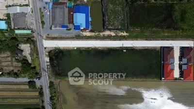 Aerial view of a rural area with roads, buildings, and green fields.