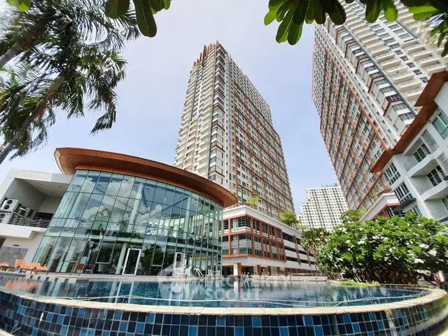 Stunning modern high-rise buildings with a luxurious pool and lush greenery, perfect for urban living.