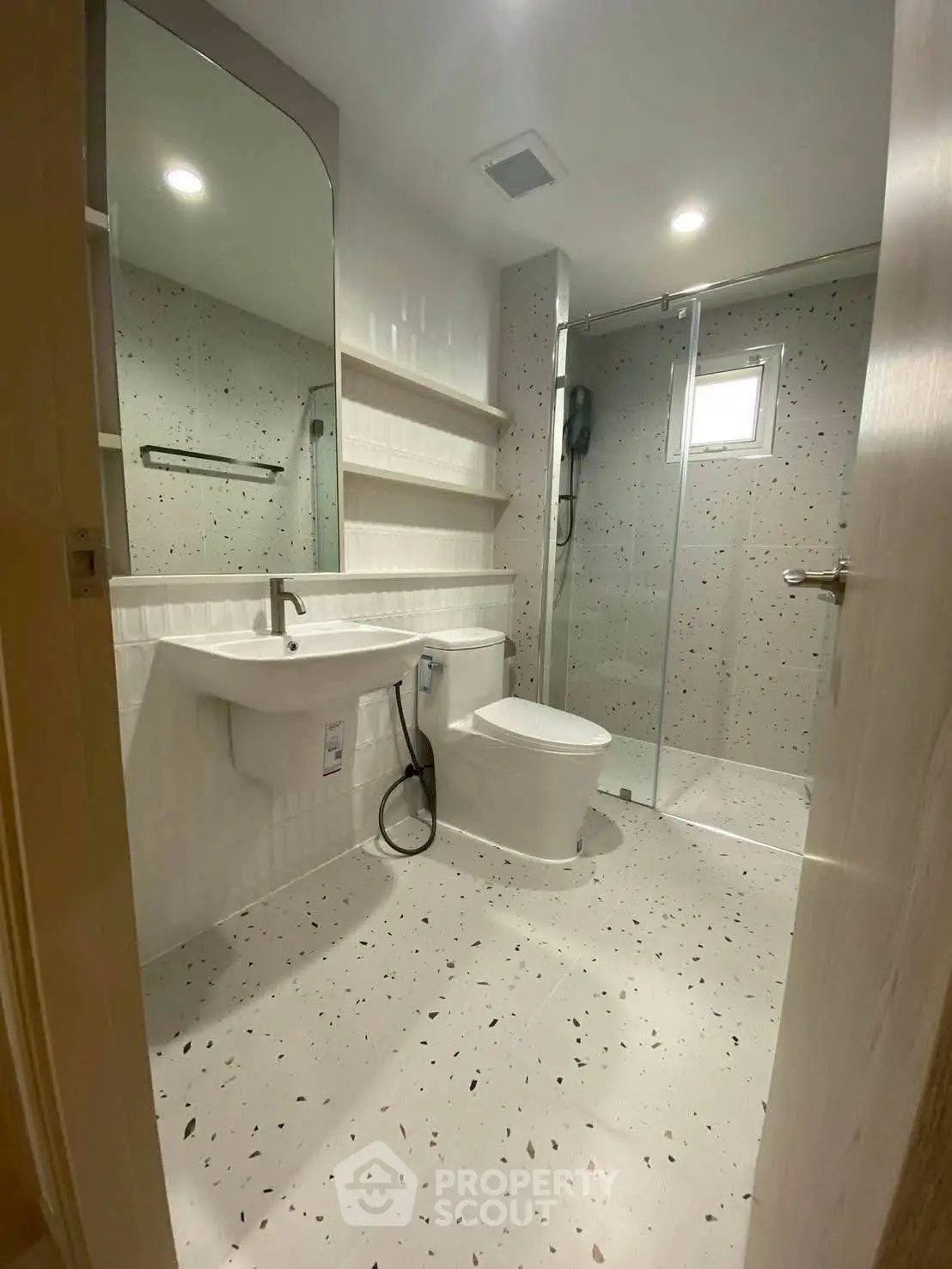 Modern bathroom with sleek design, featuring a glass shower and contemporary fixtures.