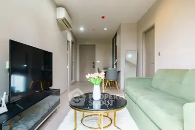 Modern living room with sleek furniture and stylish decor, featuring a large TV and elegant coffee table.