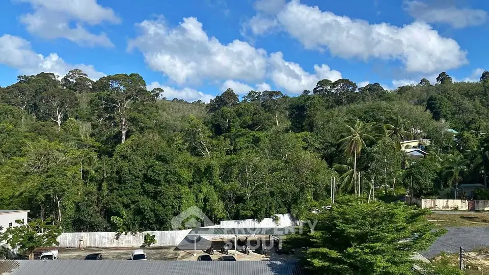 Scenic view of lush greenery and residential area under a clear blue sky, perfect for nature lovers.