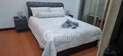 Cozy bedroom with modern decor and neatly arranged bed linens, perfect for relaxation.