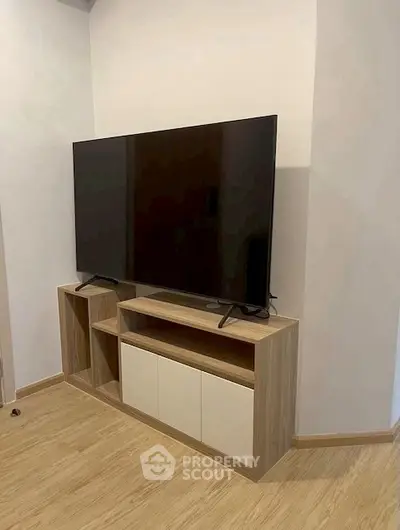 Modern living room with sleek TV stand and large flat-screen TV