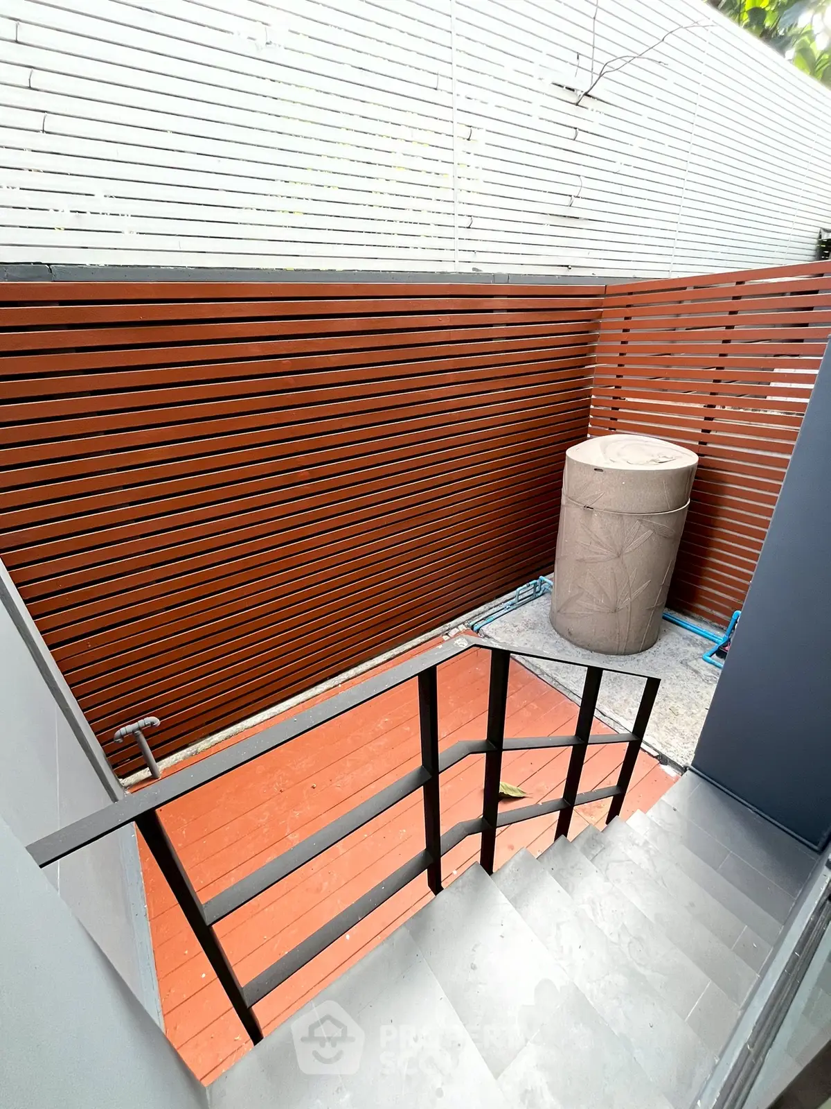Modern outdoor staircase with sleek railing and privacy fence, perfect for urban living.