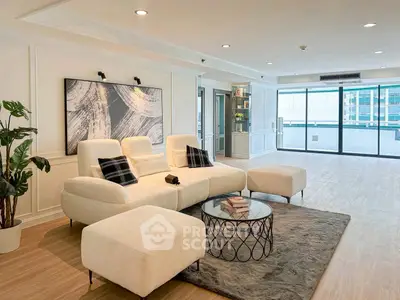 Spacious modern living room with elegant decor and large windows offering city views.